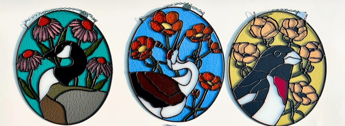 Set of three oval stained glass pieces with various birds and floral designs on a white background.