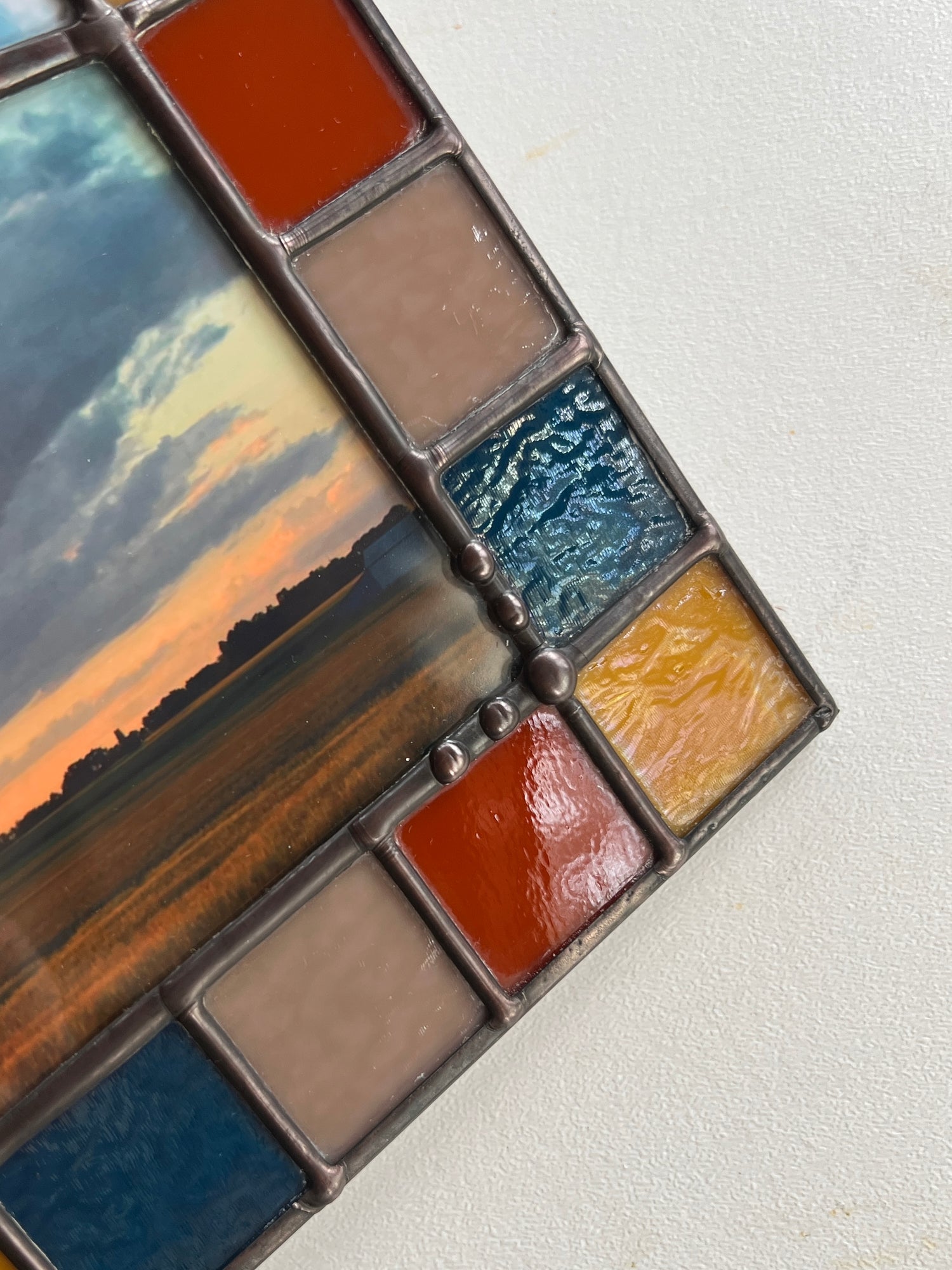 Close up of solder details and a colorful glass border on a stained glass panel