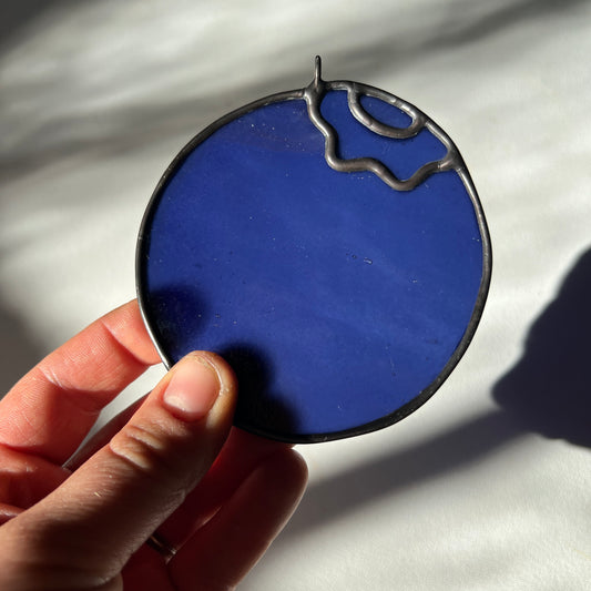 hand holding a stained glass blueberry