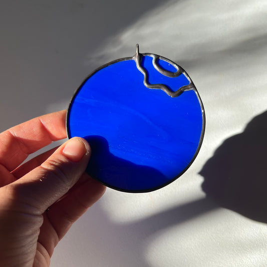 hand holding a little stained glass blueberry
