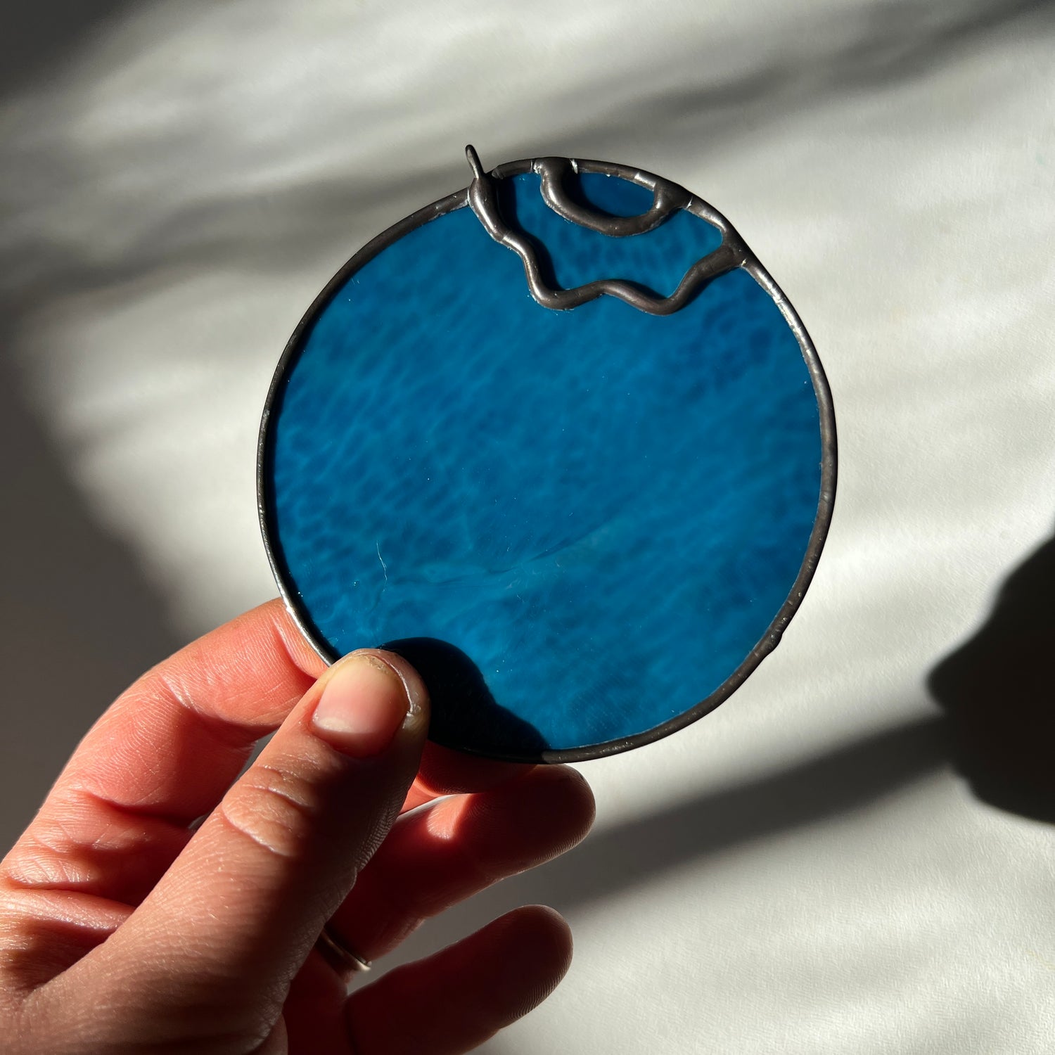 hand holding a stained glass blueberry