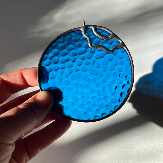 hand holding a textured stained glass blueberry