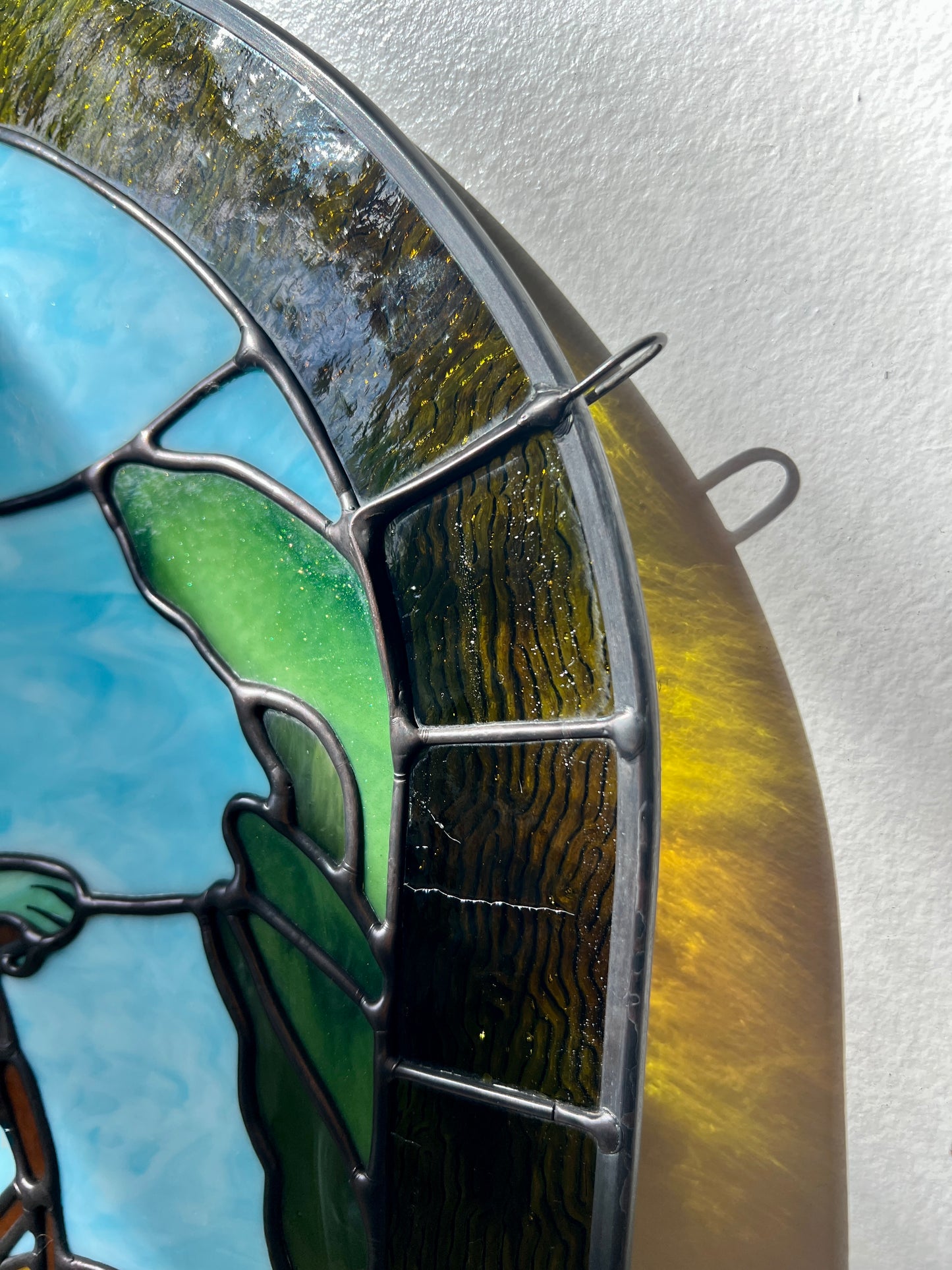 close up of a stained glass panel depicting frog and toad riding a bicycle 