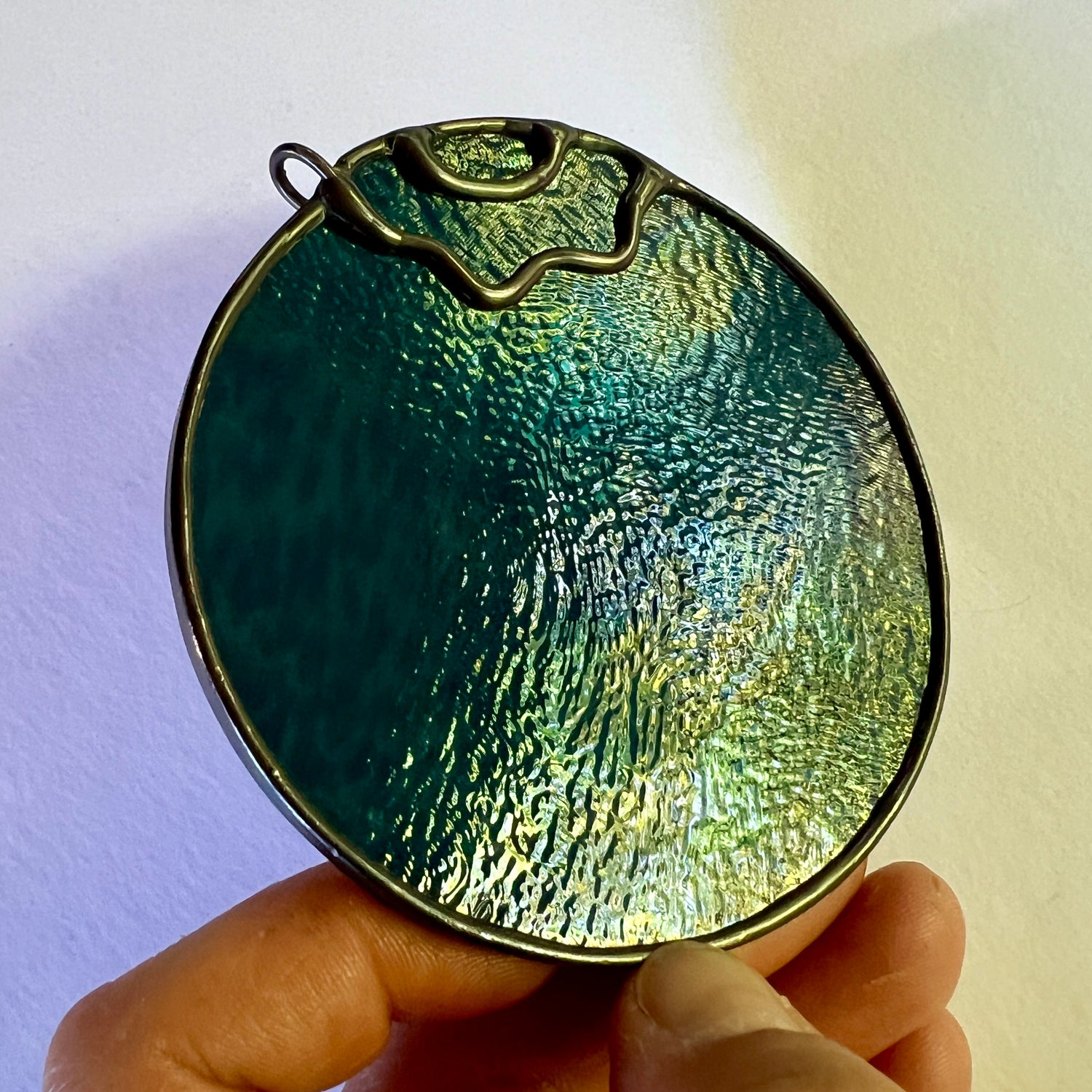 photo of a stained glass blueberry at an angle demonstrating some stains on the surface of the glass