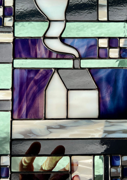 Close up of a stained glass geometric textile inspired panel depicting a cozy home in the center, with soft backlighting showcasing vibrant shades of purple, soft shades of gray, and pastel shades of sea foam.