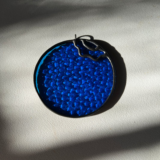 textured stained glass blueberry on white surface
