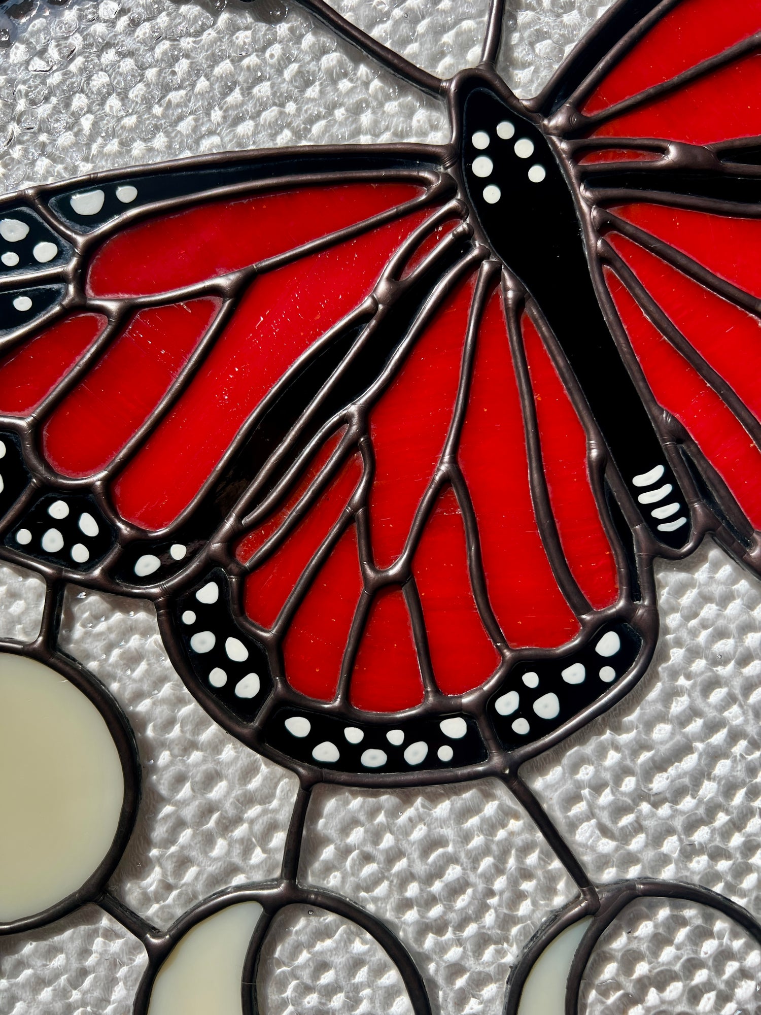 Close up of the smooth solder and hand painted details of a stained glass monarch butterfly design.
