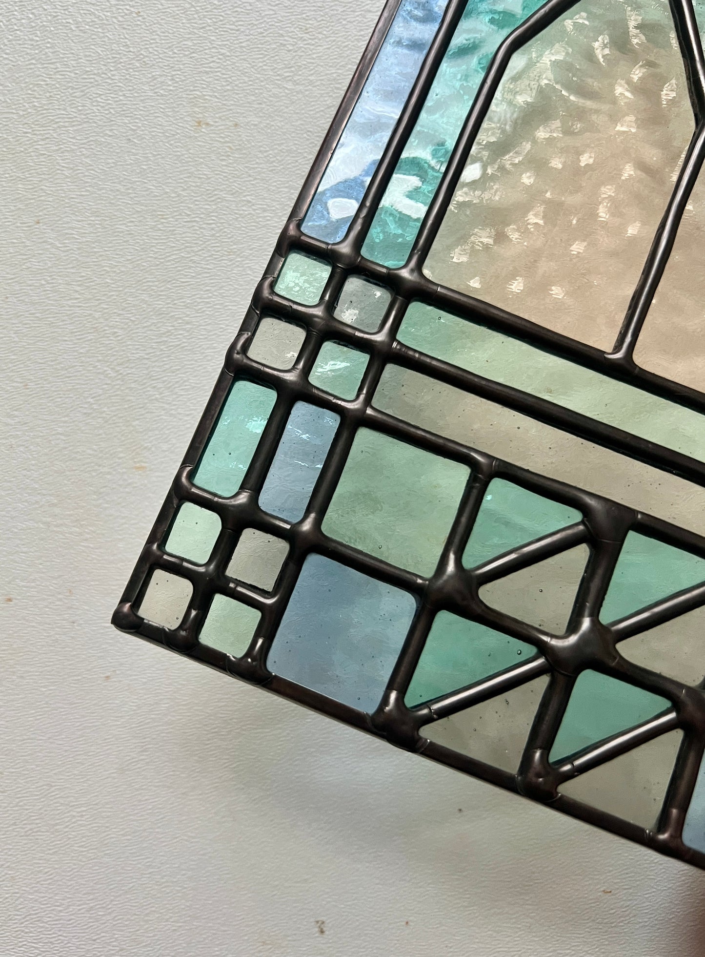 Close up view of smooth soldering details on textile inspired cozy home stained glass piece